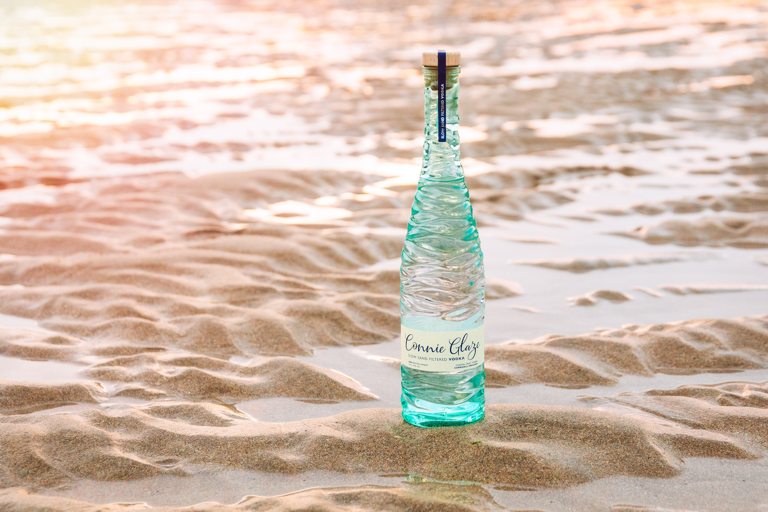 Bottle of Connie Glaze vodka on the sand Southwestern Distillery Cornwall