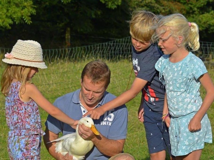 man holding duck with children