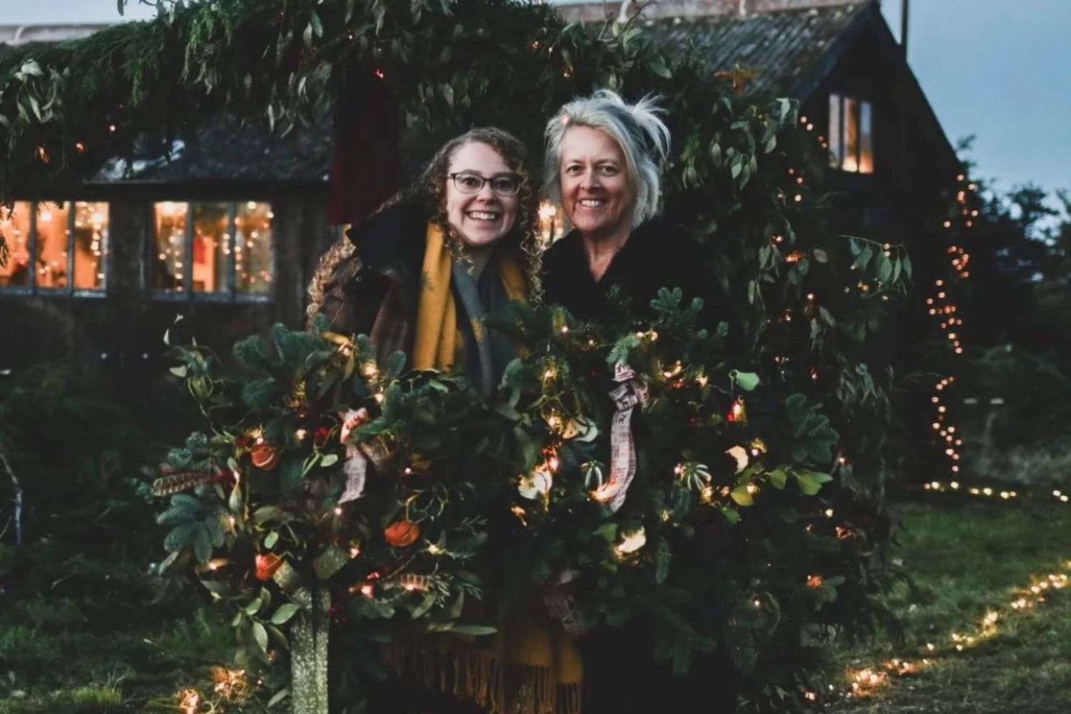 two women holding christmas wreaths